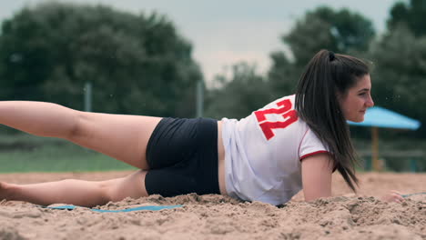 Slow-motion:-a-Young-woman-jumping-in-the-fall-hits-the-ball-on-the-sand.-Volleyball-player-makes-a-team-and-plays-the-ball-off-in-the-fall.